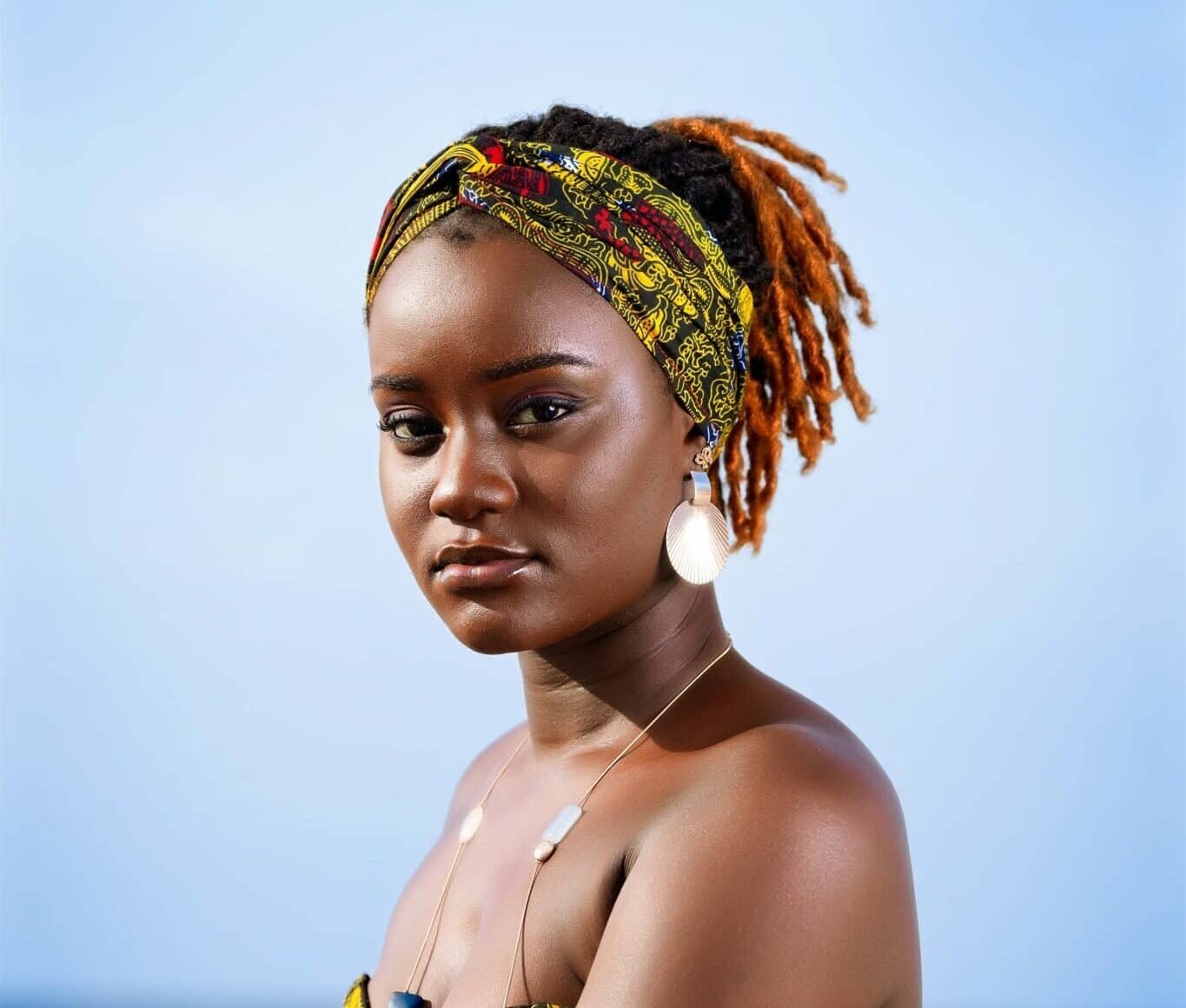 Close-up view of African female model Yacine next to a boat at the seaside in Senegal, shot 3